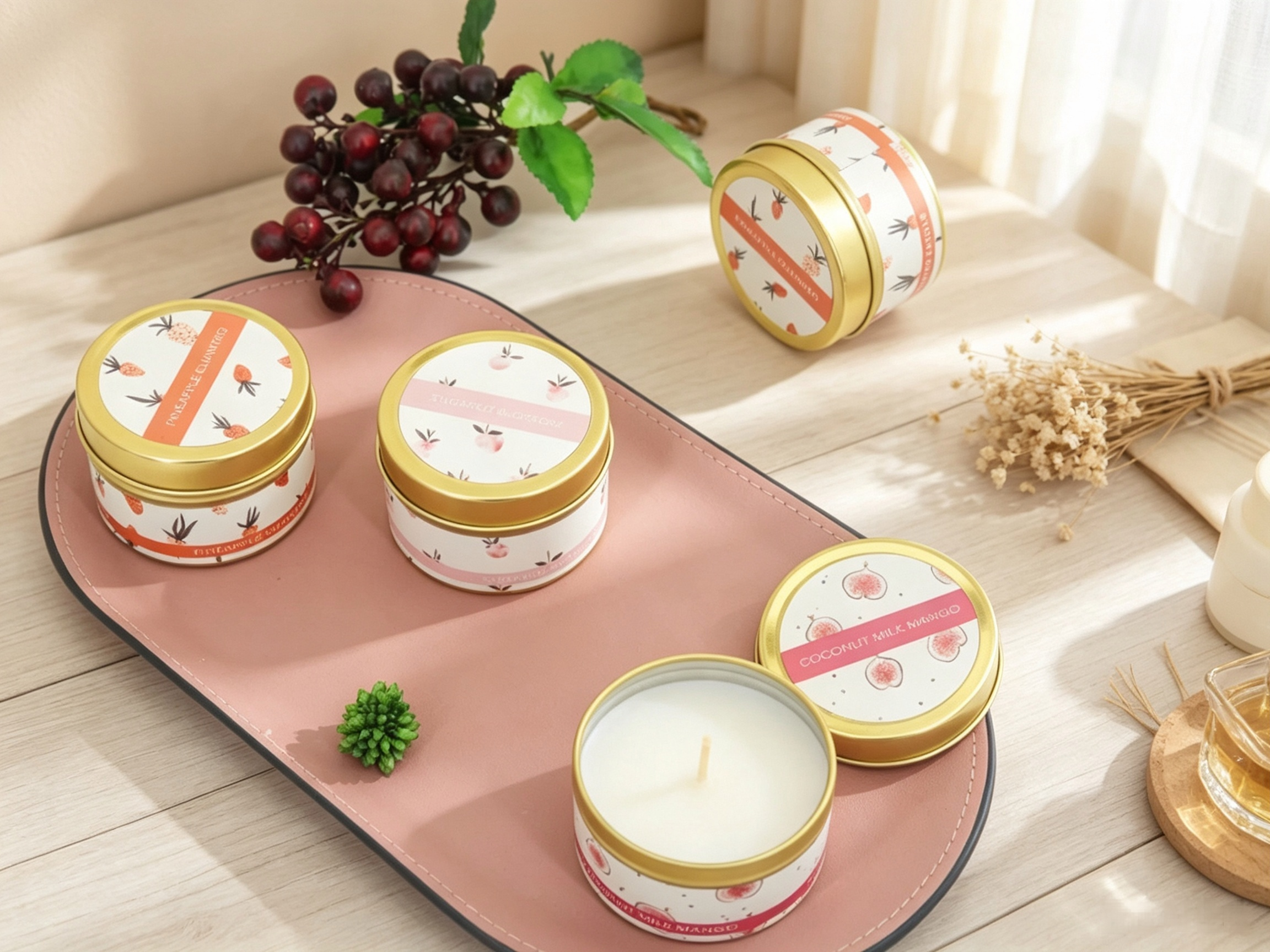 gold rim soy wax tin candles with fruit themed labels on a pink tray - home fragrance gifts.png